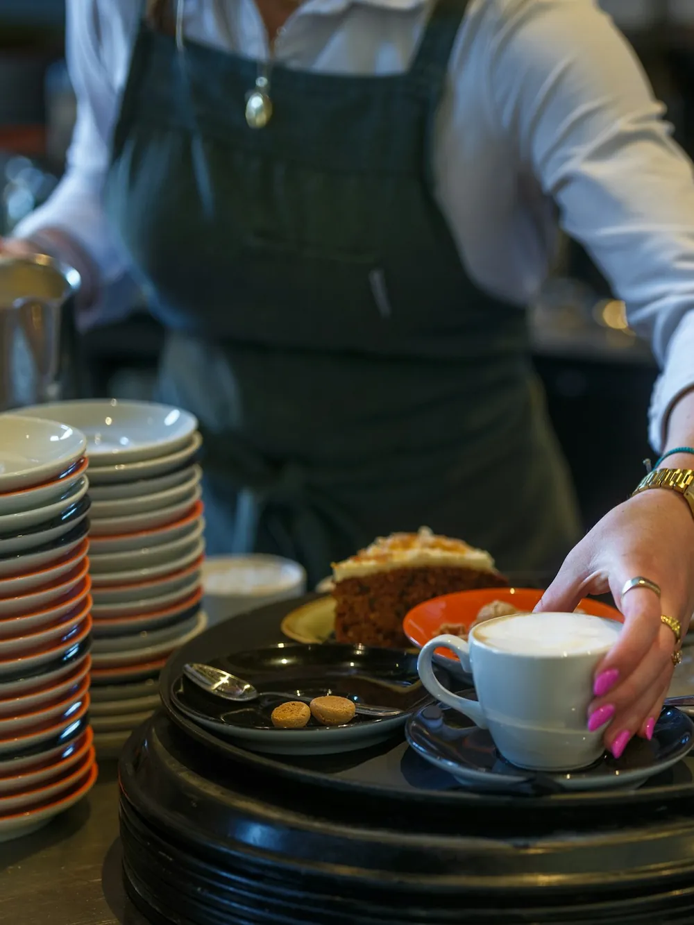 Membre de l'équipe préparant les cafés du matin derrière le zinc