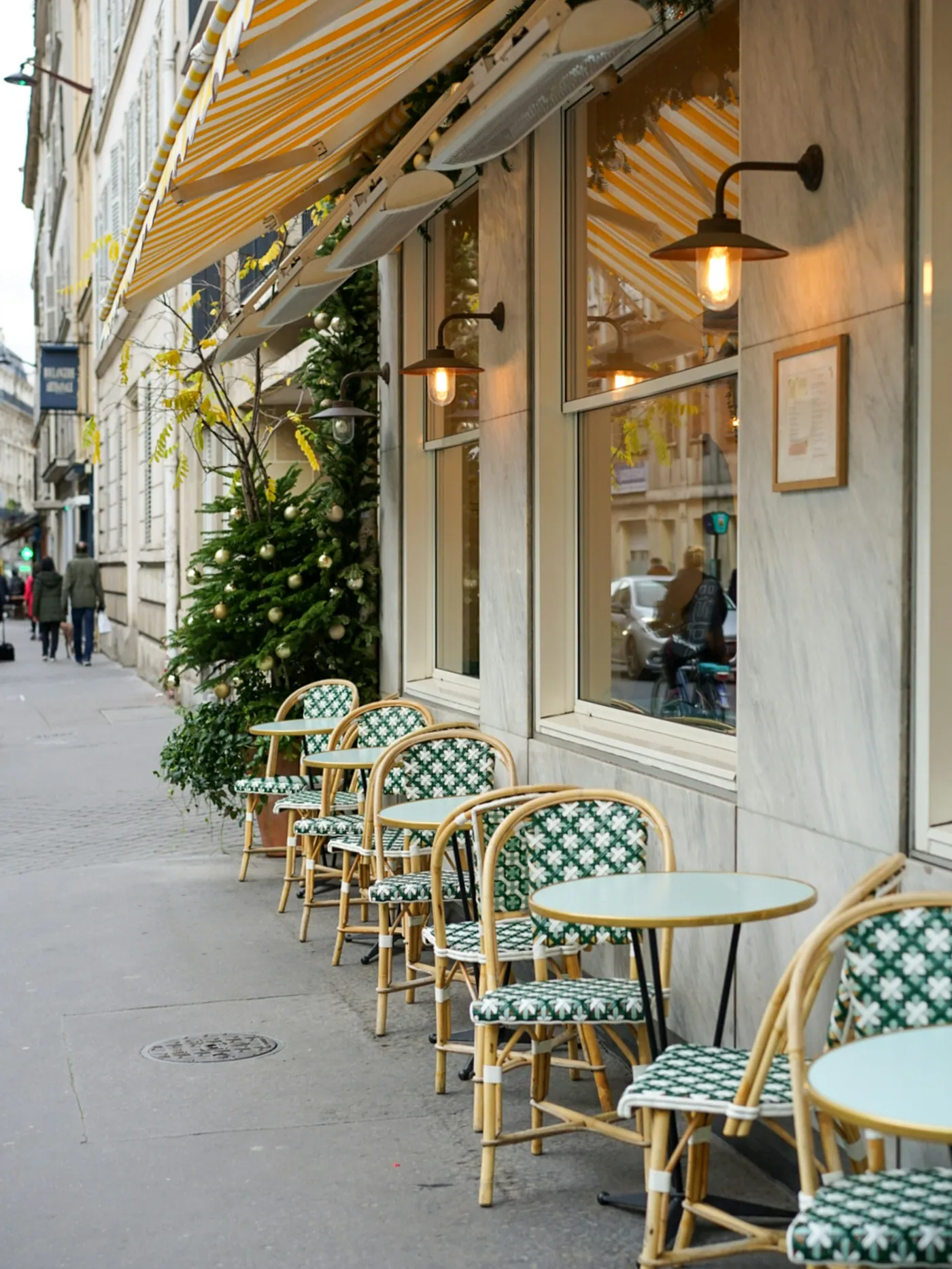 Terrasse extérieure avec tables et chaises bistrot sous l'auvent